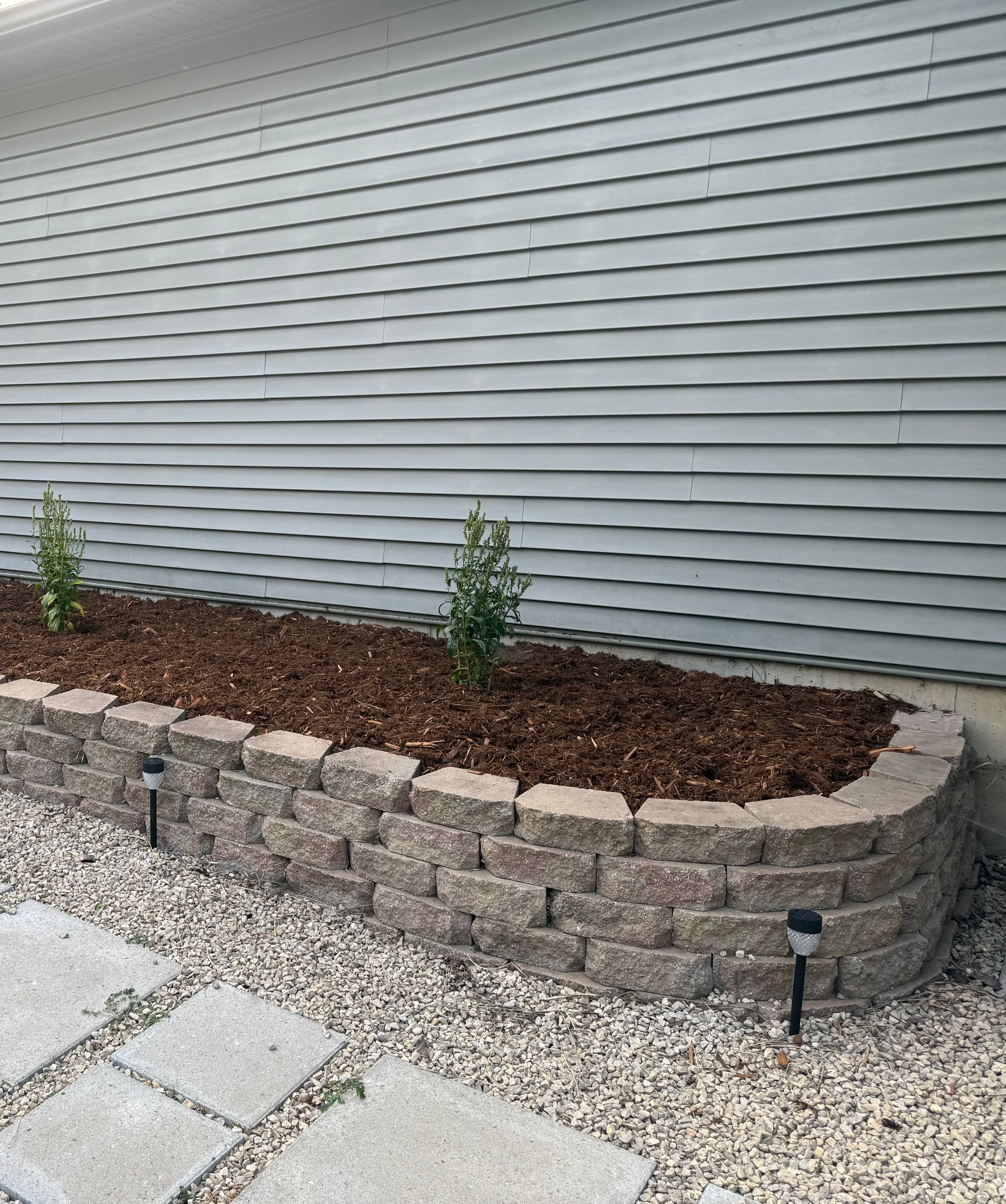 Fresh red mulch bed with boulder edging installed by Schreed Outdoor Services