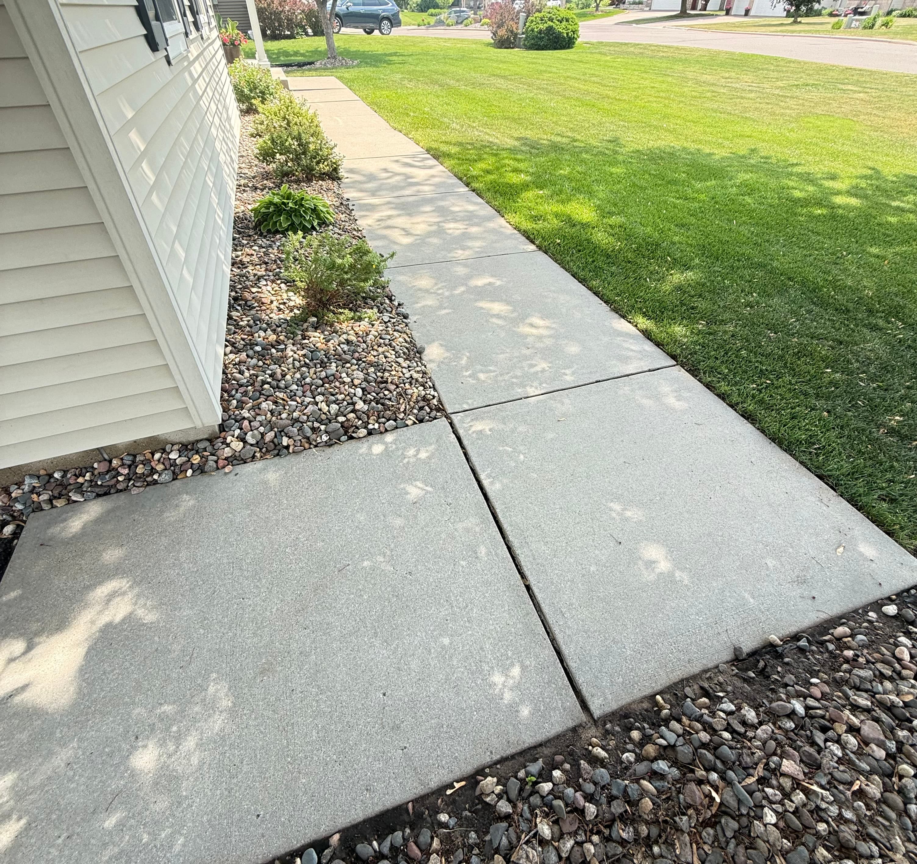 Surface cleaner and pressure washer hose set up on a concrete walkway job